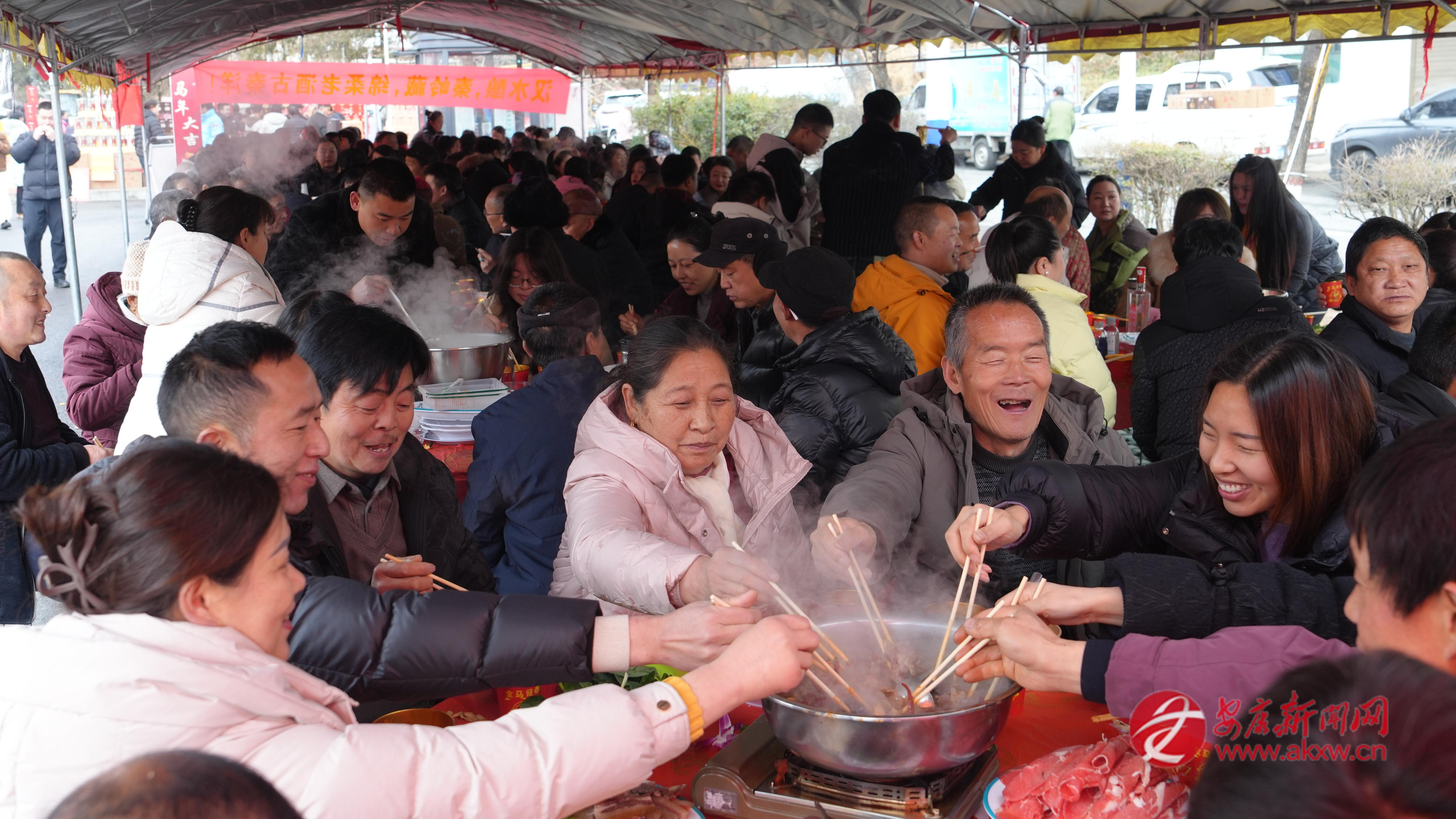 在寧陜縣江口鎮全牛火鍋宴上,食客一起品嘗火鍋。
